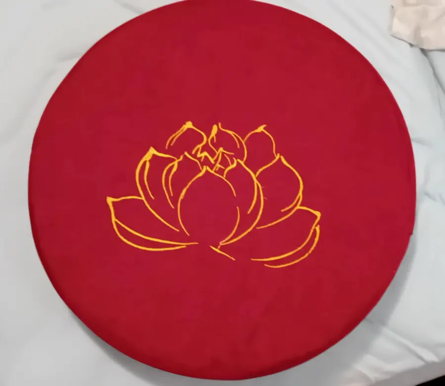 Buyer photo of a bright red meditation cushion with gold lotus embroidery
